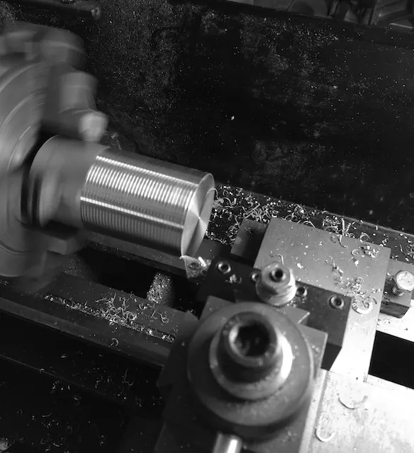 Black and white photo of a part being turned on a lathe