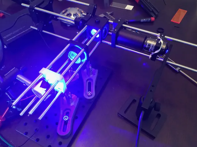 Optics on rails lit by a blue laser