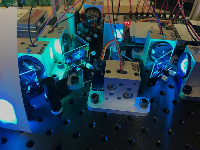 An optical breadboard with blue-lit cubes and wiring