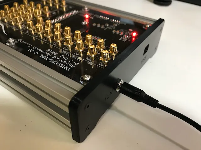 An early Triggerscope V-3B controller with rows of gold SMA connectors and red status LEDs