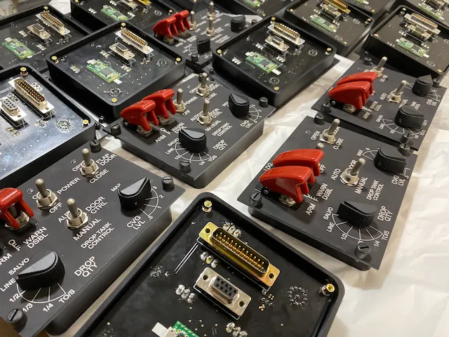 Rows of control panels with red toggle switches, mid-build
