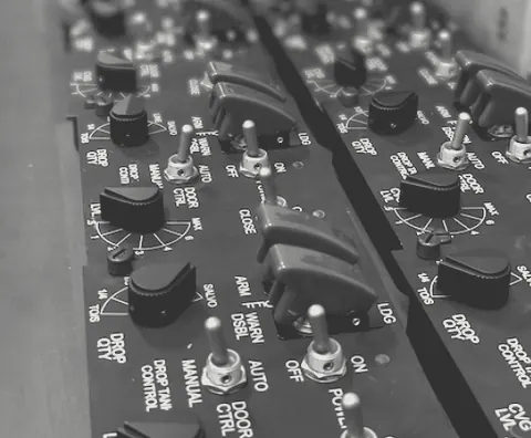 Close-up of hand-labelled control panels with red toggle switches