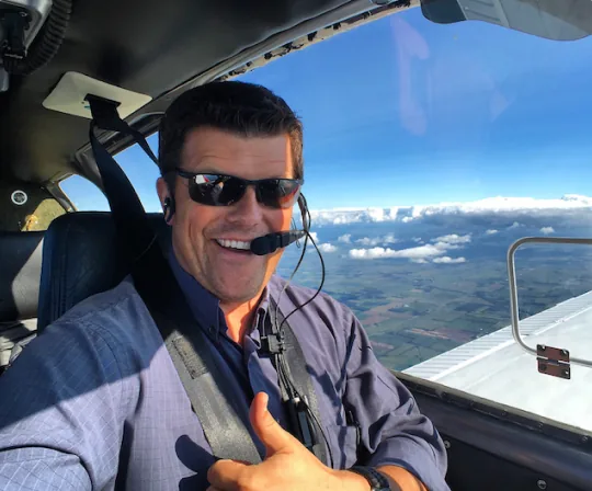 An ARC team member giving a thumbs up from the cockpit of a small plane